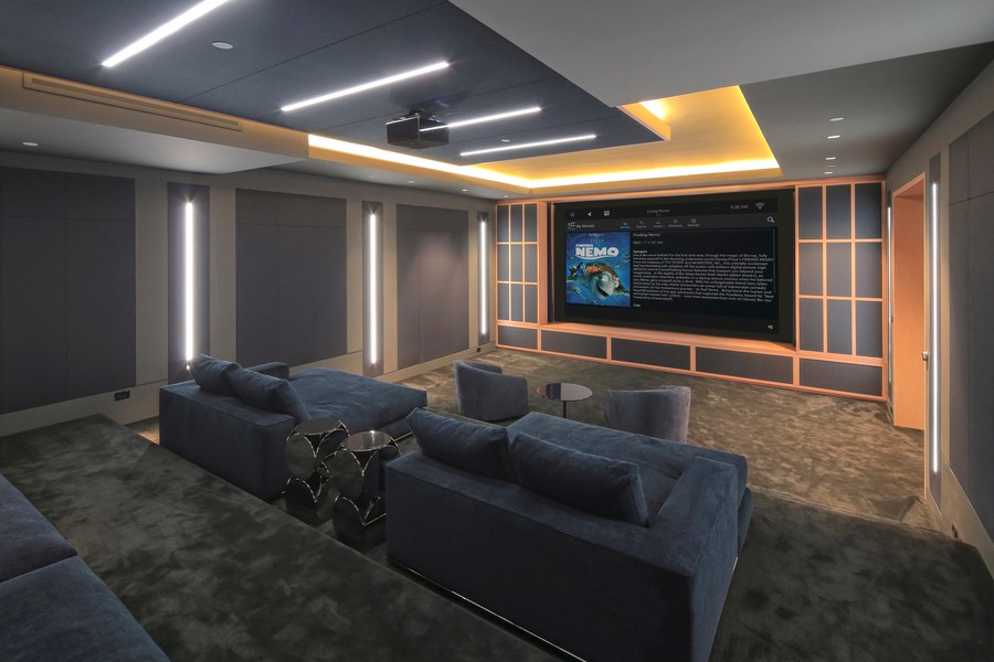 A home theater featuring a ceiling-mounted projector and projector screen. 