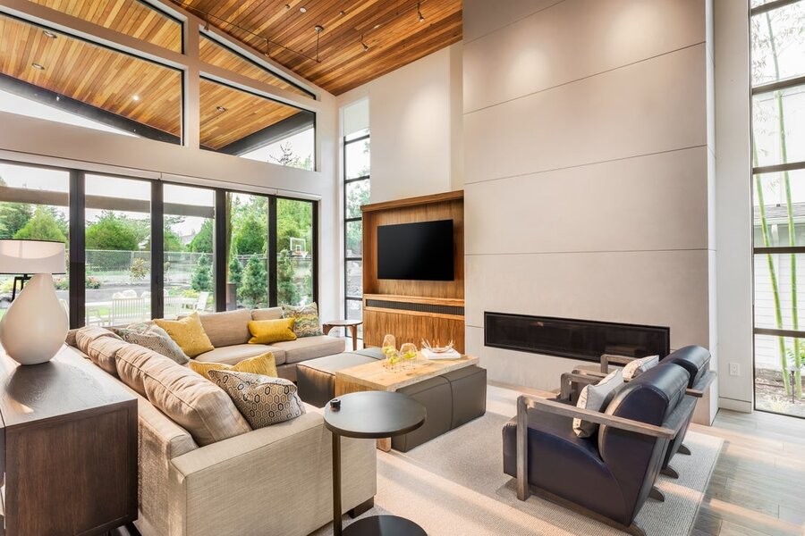 An open living space featuring smart home automation solutions like smart lighting fixtures and a flatscreen TV mounted on the wall. 
