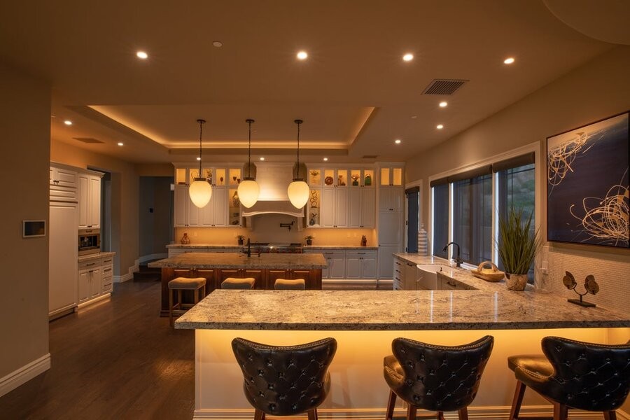 A kitchen space with many Control4 lighting fixtures as part of a professional lighting design and setup.
