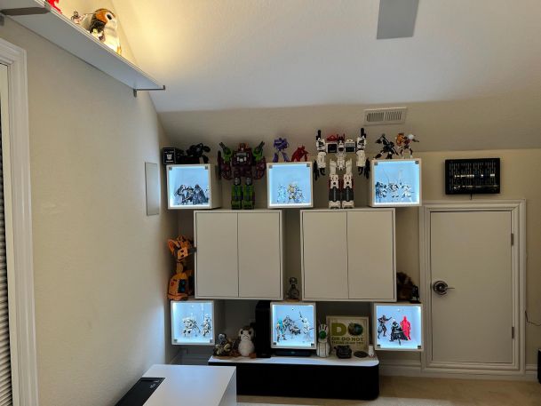 A focused view of illuminated shelves showcasing action figures and collectibles.