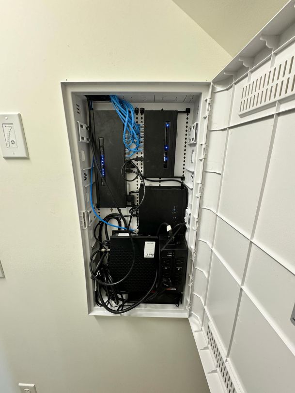 Open network equipment enclosure with cables and electronic components organized inside.