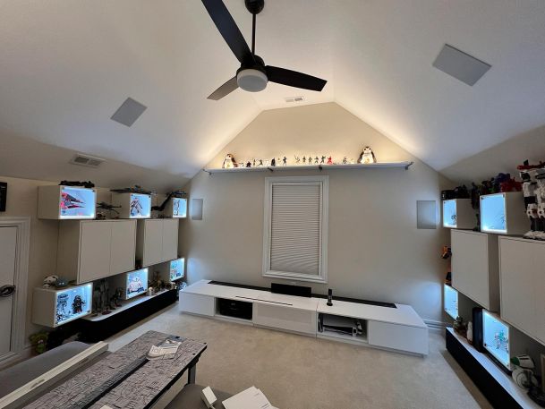 A spacious room with vaulted ceilings displaying collectibles on shelves and in lit cases.