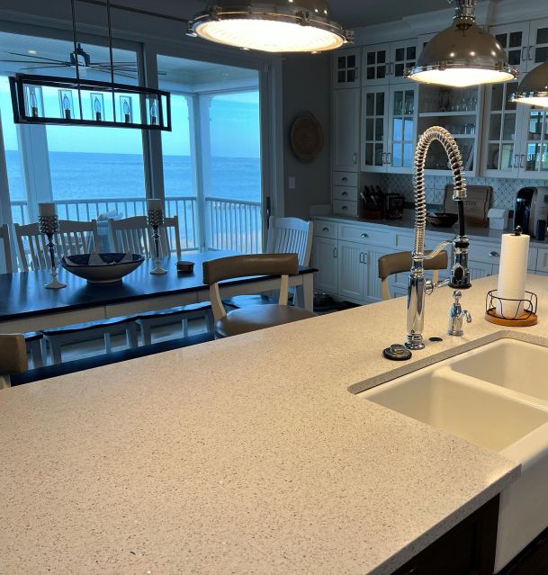 A sleek kitchen countertop and sink area with a modern faucet and ocean view in the background.